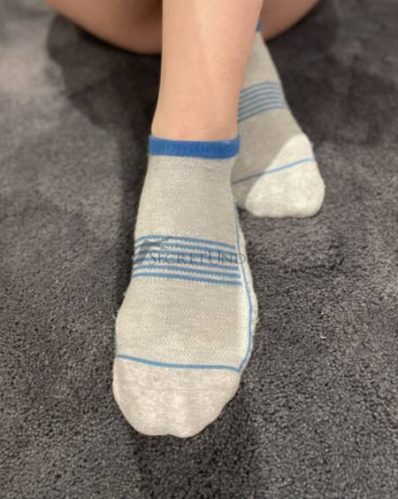Graue Socken mit blauen Streifen und Löchern