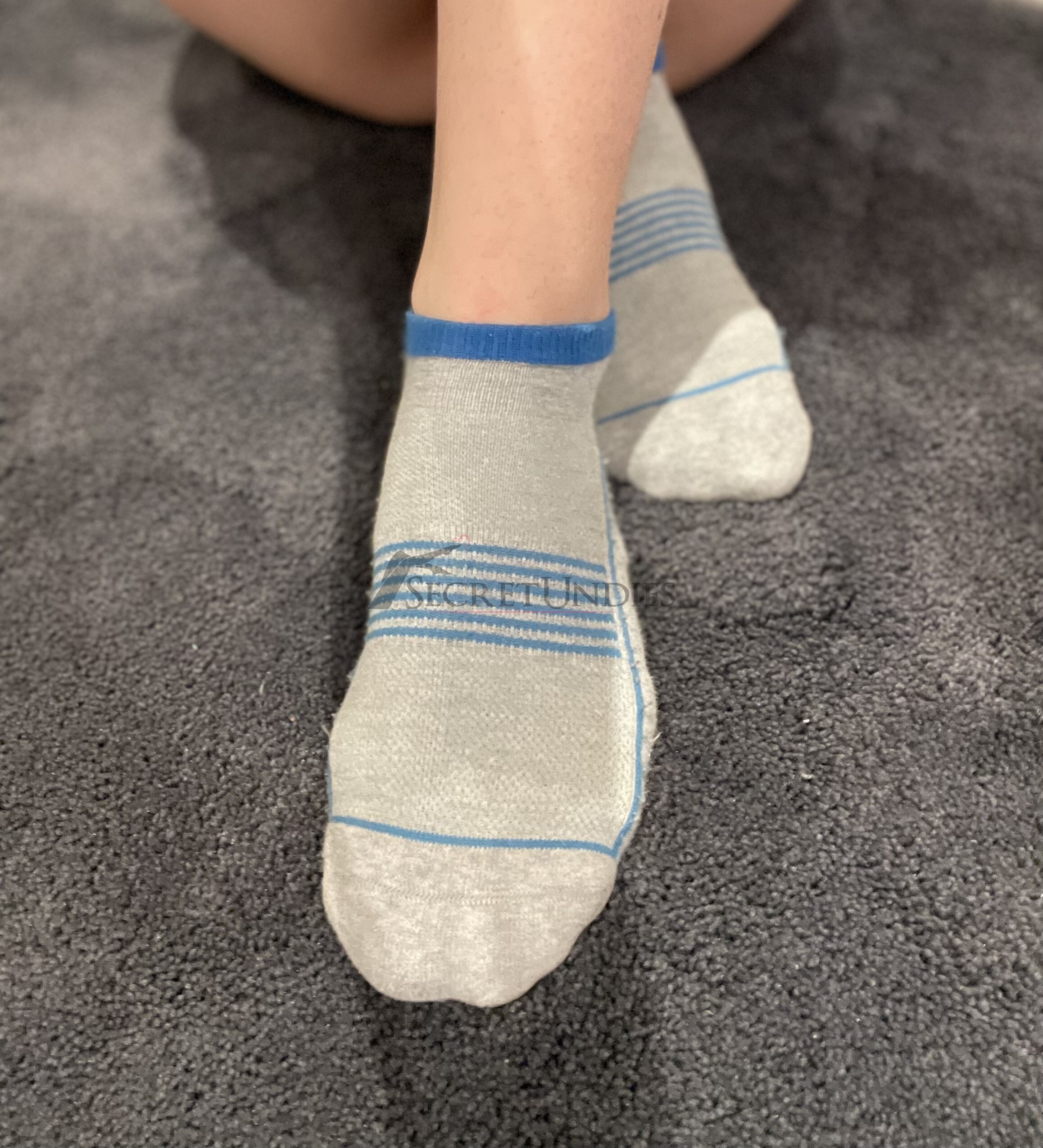 Graue Socken mit blauen Streifen und Löchern
