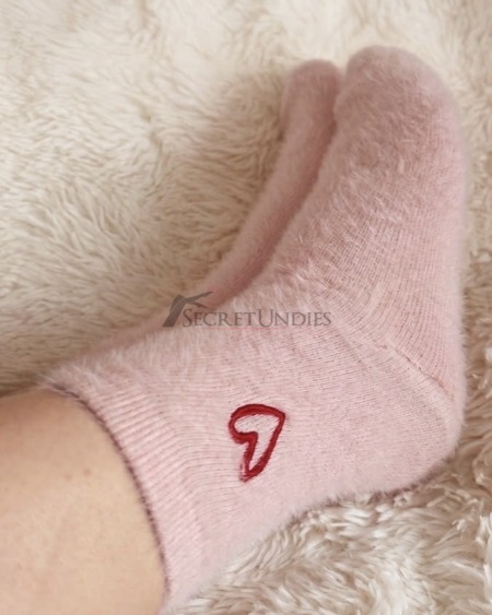 Kuschelige rosa Lieblingssocken, getragen im Bett mit den allerschönsten Gedanken
